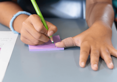 Student writing on a sticky note