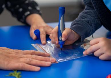 Teacher and student marking up a sample collection bag