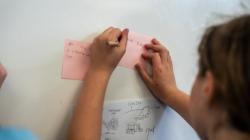 Student writing on a sticky note